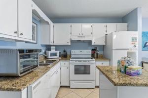 eine Küche mit weißen Geräten und weißen Schränken in der Unterkunft Plantation 1211 in Gulf Highlands