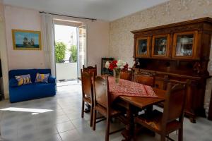 a dining room with a table and a blue couch at Villa Azzurra Apartment Camilleri's Roads in Porto Empedocle