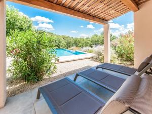 a patio with a table and chairs and a swimming pool at Holiday Home in Vaison la Romaine with Pool in Vaison-la-Romaine