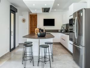 a kitchen with a island with stools and a refrigerator at Holiday Home in Vaison la Romaine with Pool in Vaison-la-Romaine
