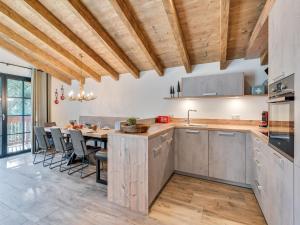 a kitchen with wooden ceilings and a table with chairs at Chalet in Krimml near Zillertal Ski Arena in Krimml