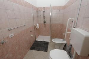 a small bathroom with a toilet and a shower at Villa Azzurra Apartment Camilleri's Roads in Porto Empedocle