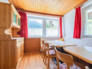 a kitchen with red curtains and a table and chairs at Chalet in Tyrol near Ski Resort in Piller