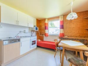 a kitchen with a table and a red couch at Chalet in Tyrol near Ski Resort in Piller +32 photos