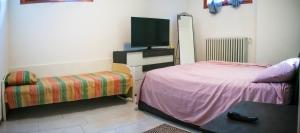 a bedroom with a bed and a tv and a chair at Fiorano, Relax e motori Ferrari in Fiorano Modenese