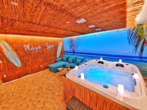 a bath tub in a room with a couch at PLAYA SPA-4 Pers-Jacuzzi-Parking-Jardin-Clim-Colmar in Muntzenheim +11 photos