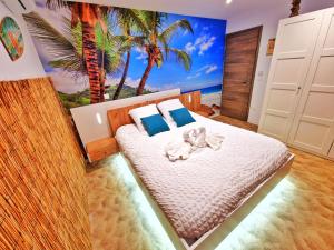 a bedroom with a bed with a palm tree mural at PLAYA SPA-4 Pers-Jacuzzi-Parking-Jardin-Clim-Colmar in Muntzenheim