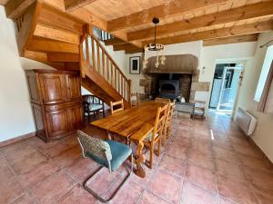 a dining room with a wooden table and a fireplace at Maison bretonne, Gîte de Keranglaz in Ploubezre +10 photos