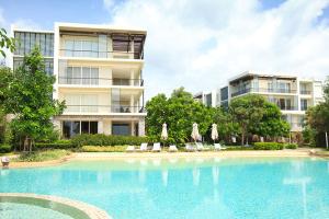 a large swimming pool in front of a building at Baan Nub Kluen Condo - Hua Hin in Ban Khao Takiap