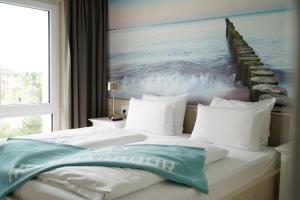 Un dormitorio con una cama con un cuadro del océano. en Comfort One Bedroom, en Heiligenhafen