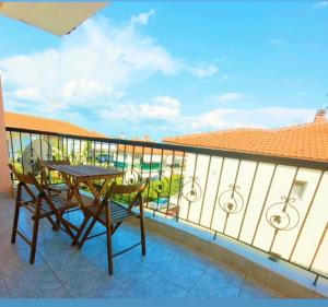 a balcony with a table and chairs on it at Isolde Apartment in Kallithea Halkidikis