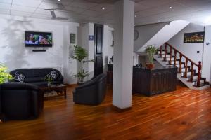un vestíbulo con sofás y TV en la pared en L&D Lodge en Hikkaduwa