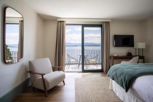 a bedroom with a bed and a view of the water at Maison du Lac Boutique Hôtel in Nyon