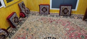 a room with four chairs and a rug at Mir guest house in Tangmarg