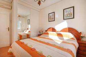 Un dormitorio con dos camas con sábanas naranjas y blancas. en Bungalow with community pool - Vallesa4H, en Ifach
