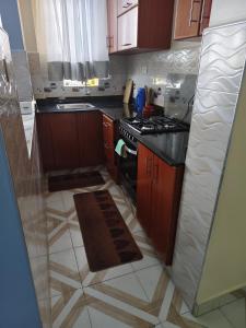 a kitchen with wooden cabinets and a stove top oven at Effiehomes in Munyu