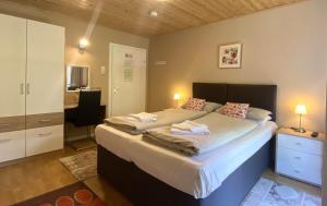 a bedroom with a large bed and a desk at Pension Julia in Feld am See