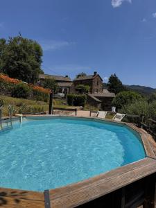a large swimming pool with two chairs around it at Les hôtes du châtaignier in Pénens +67 photos