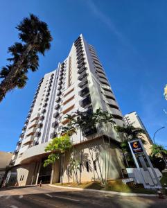 Un edificio alto y blanco con una palmera delante. en Quarto 5 estrelas no Comfort Suites!, en Brasilia 22 fotos más