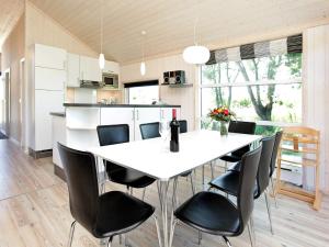 a kitchen with a white table and black chairs at Holiday home in Großenbrode in Großenbrode +10 photos