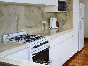 a white kitchen with a white stove top oven at Annabelle's in Saint James +94 photos