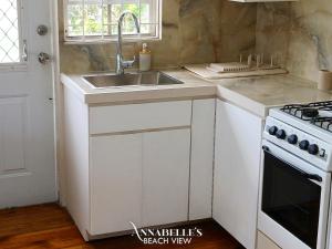 a white kitchen with a sink and a stove at Annabelle's in Saint James