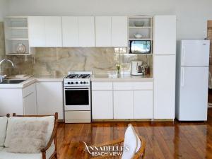 a kitchen with white cabinets and a white refrigerator at Annabelle's in Saint James