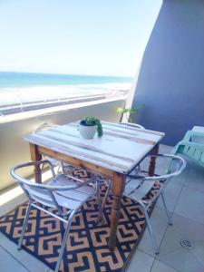 a table and chairs on a balcony with a view of the ocean at Umdloti Holiday Resort 607 in Umdloti
