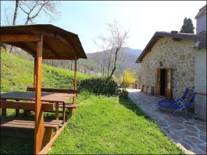 a building with a wooden table and a blue chair at Cottage in Casoli near Ski Slopes in Cocciglia