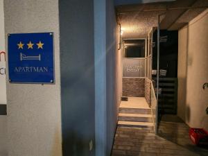 a hallway with a blue sign on the side of a building at Best apartman in Gornji Kneginec