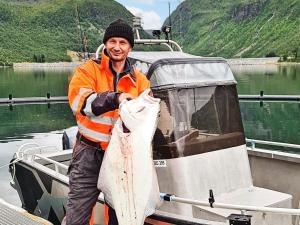 a man holding a fish on a boat at 8 person holiday home in Kaldfarnes in Kaldfarnes