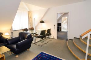ein Wohnzimmer mit Tisch und Stühlen in der Unterkunft Hotel Schere in Northeim