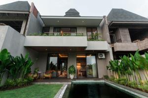 a house with a swimming pool in front of it at Renjana Villas in Ubud