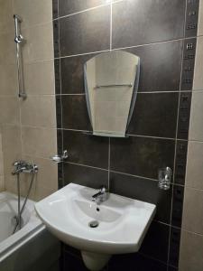 a bathroom with a sink and a mirror and a tub at Aspen Valley in Razlog +10 photos