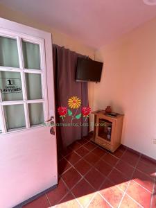 Habitación con puerta y TV en la pared en Apartamentos Las Flores, en Villa Carlos Paz 33 fotos más