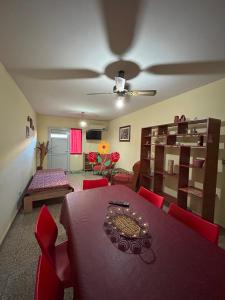 Un comedor con una mesa y sillas rojas. en Apartamentos Las Flores, en Villa Carlos Paz