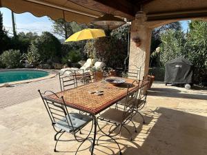 een tafel met stoelen en een parasol naast een zwembad bij Holiday Home in Lorgues with Pool in Lorgues