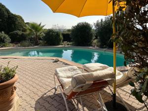 een paar stoelen en een parasol naast een zwembad bij Holiday Home in Lorgues with Pool in Lorgues