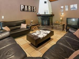 a living room with leather couches and a fireplace at Nature Retreat in Waimes in Waimes