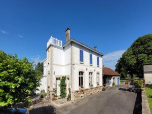 a white building with a tower on a street at Holiday Home in Limousin near Forest in Sainte-Anne-Saint-Priest