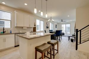 una cocina con armarios blancos y un bar con taburetes en Community Perks Executive Chandler Townhome, en Chandler