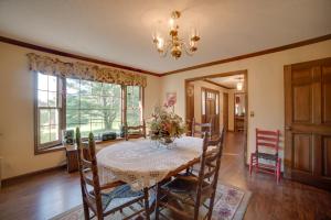 Un comedor con una mesa y sillas y una lámpara de araña. en Dayton Home with Pool and Deck on 37 Private Acres!, en Dayton