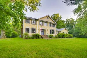 una gran casa amarilla con un patio de césped en Dayton Home with Pool and Deck on 37 Private Acres!, en Dayton
