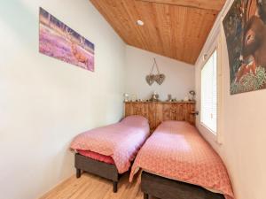 two twin beds in a bedroom with wooden ceilings at House in Hunzebergen near Forest Trails in Exloo
