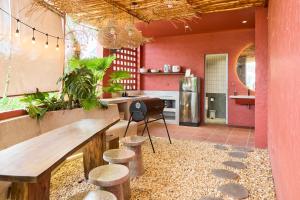 a kitchen with pink walls and a wooden table and stools at Kin Wander Tân Phong, The Moonage in Ho Chi Minh City