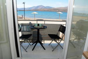 a balcony with a table and chairs and a view of the beach at Aquamarine - Beach Flat in Itea
