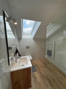 een badkamer met een wastafel, een spiegel en een raam bij The Country Stop Apartment in Łęki