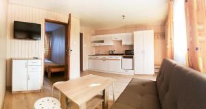 a kitchen and a living room with a couch and a table at OW NaFali in Jarosławiec +6 photos
