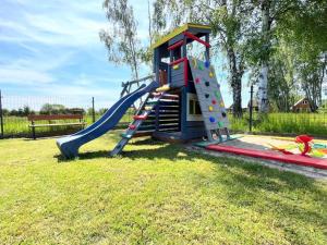 a playground with a slide in the grass at OW NaFali in Jarosławiec