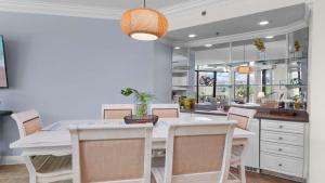 a dining room with a white table and chairs at Enjoy a 3-bedroom Bayfront Condo with Lazy River Indoor Pool Jacuzzis and Community Boat Dock for Personal or Rented Boats Plus Redeem in Free Activity Deals Daily in Orange Beach